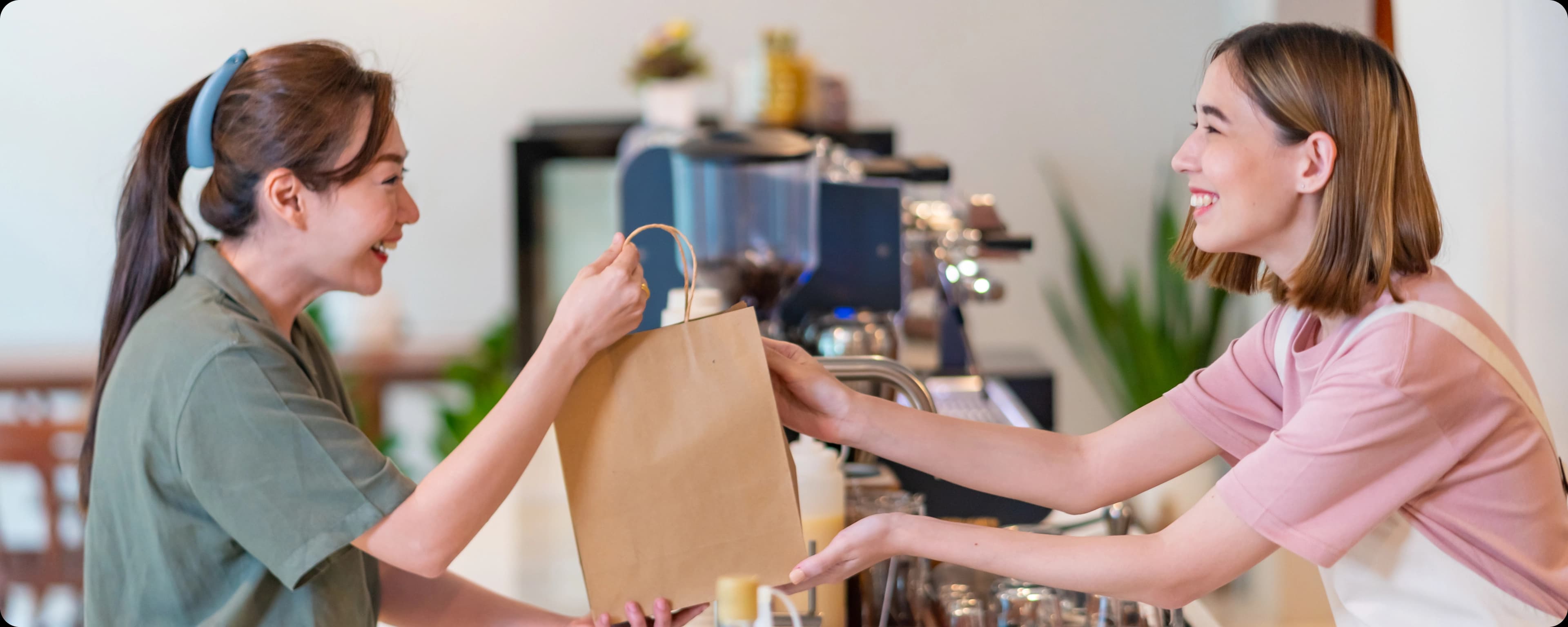 Female customer taking goods bag from cashier