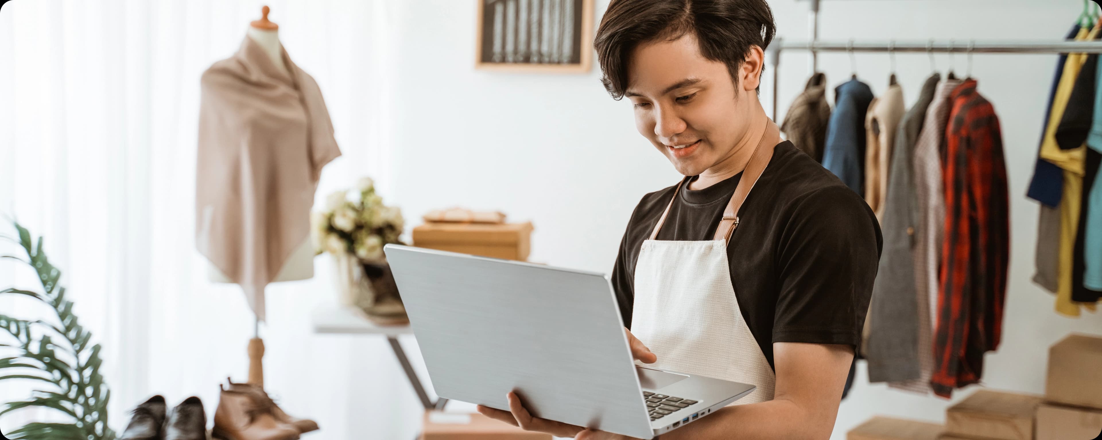 Man in apron using laptop touchpad